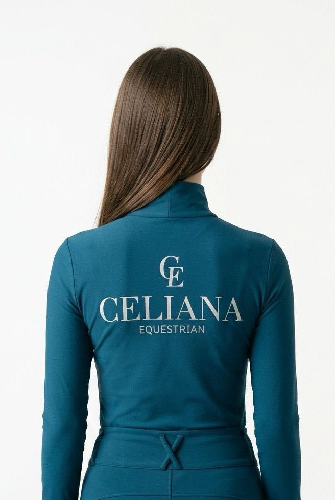 Vista trasera del base layer de equitación azul petróleo con logo CE y texto Celiana Equestrian estampado en la espalda, llevado por una amazona, fondo blanco
