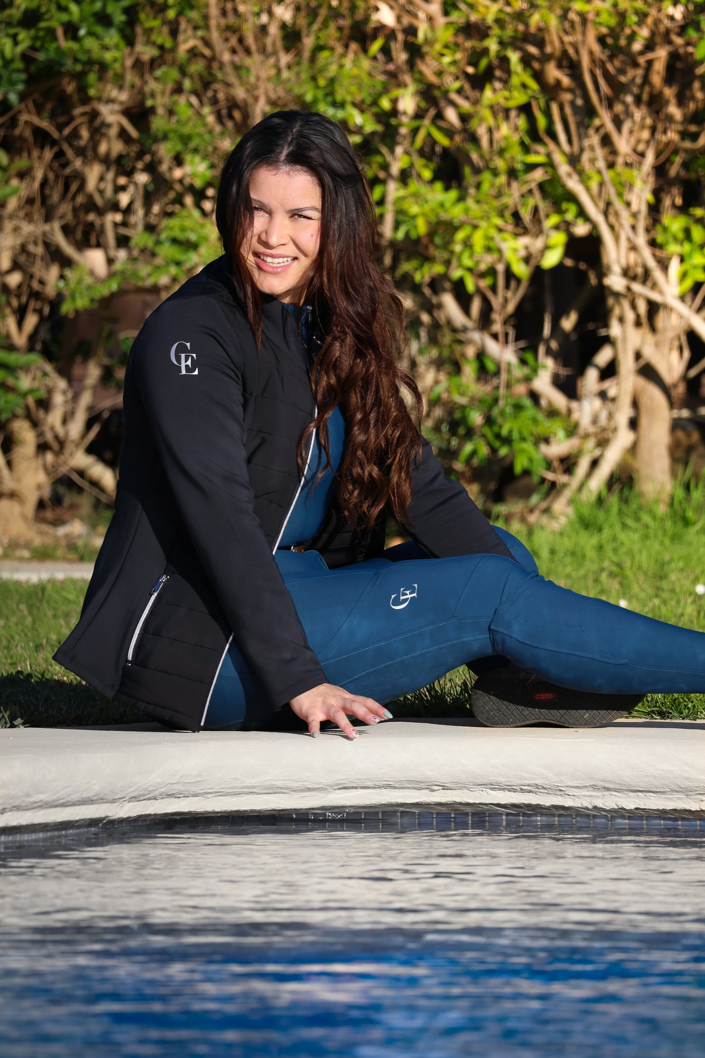 Chaqueta ecuestre técnica para mujer Celiana Equestrian en color negro, diseño elegante y funcional en un entorno exterior