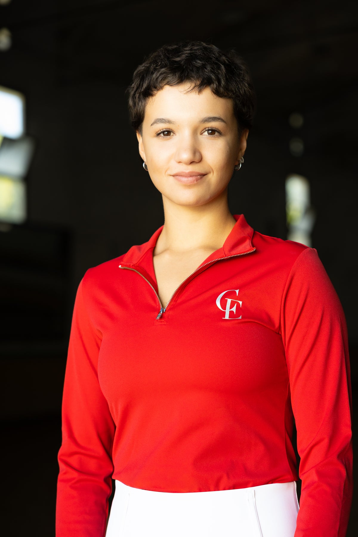 Base layer de equitación Celiana Equestrian para mujer en rojo de manga larga, detalle del cuello alto con media cremallera y logo CE bordado