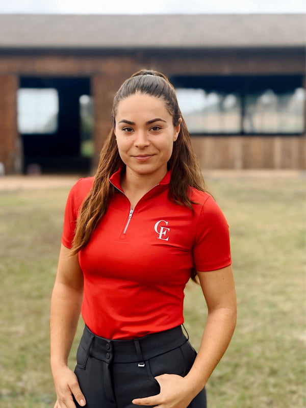Amazonas con base layer roja de equitación Celiana Equestrian Prestige de manga corta con logo CE y ajuste técnico elegante.