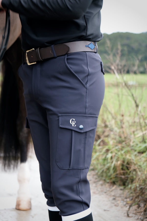 Pantalón de equitación cargo gris con logo CE puesto en mujer junto a caballo – Celiana Equestrian