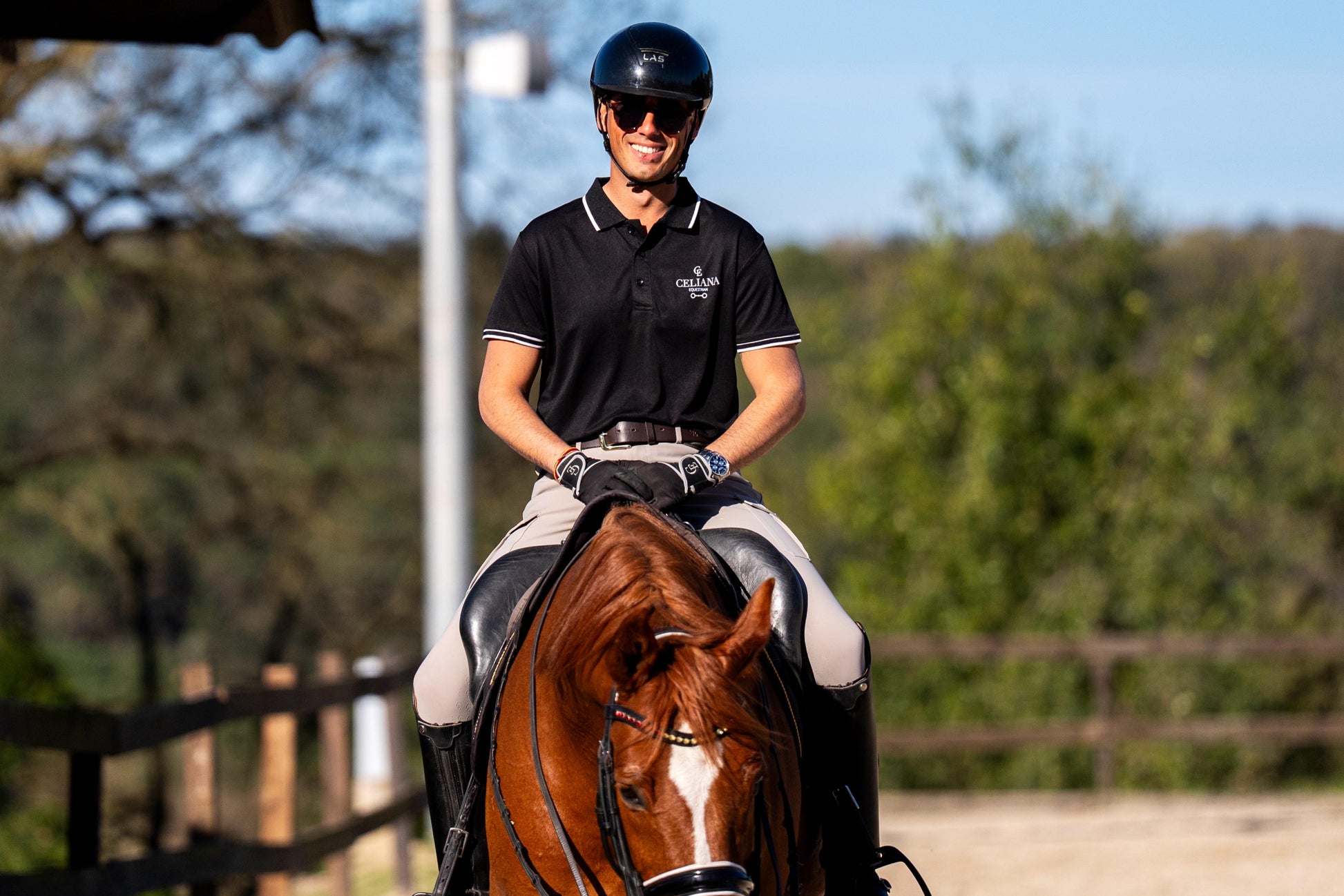 Polo de equitación negro con logo Celiana Equestrian puesto en jinete a caballo