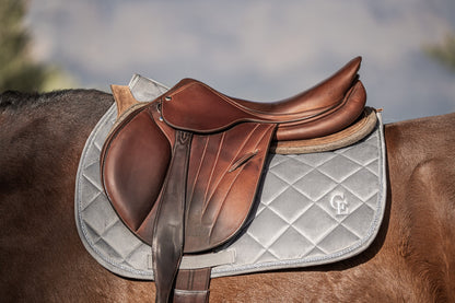 Sudadero de equitación gris con logo CE bajo silla de montar marrón en caballo – Celiana Equestrian
